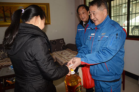 图为该公司董事长兼总经理张俊山看望已故重病员工的家